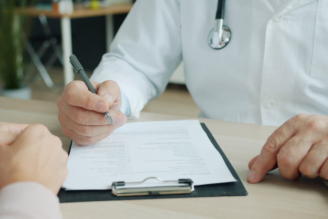 一位临床人员在就诊时在写字板上记录