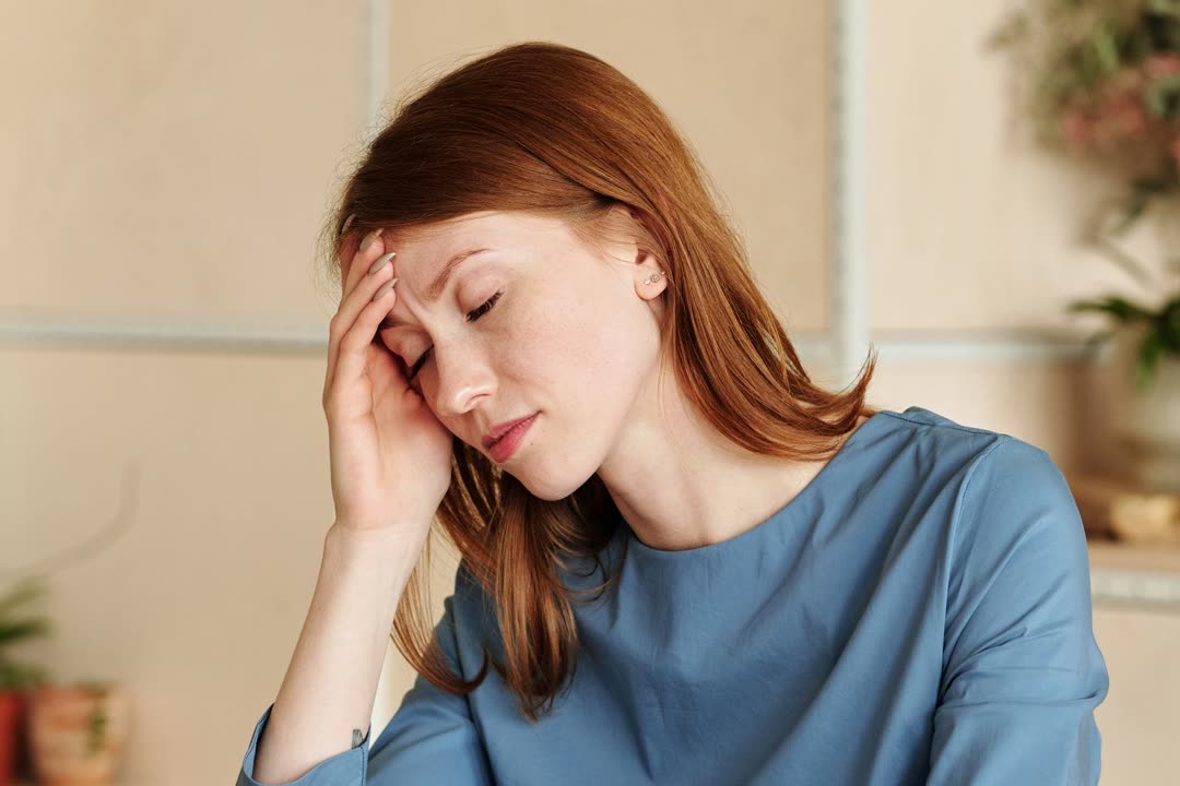 زنی خسته که پشت میز کار سرش را روی دستش گذاشته است